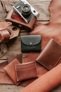 Artistic display of handcrafted leather wallets and vintage camera.